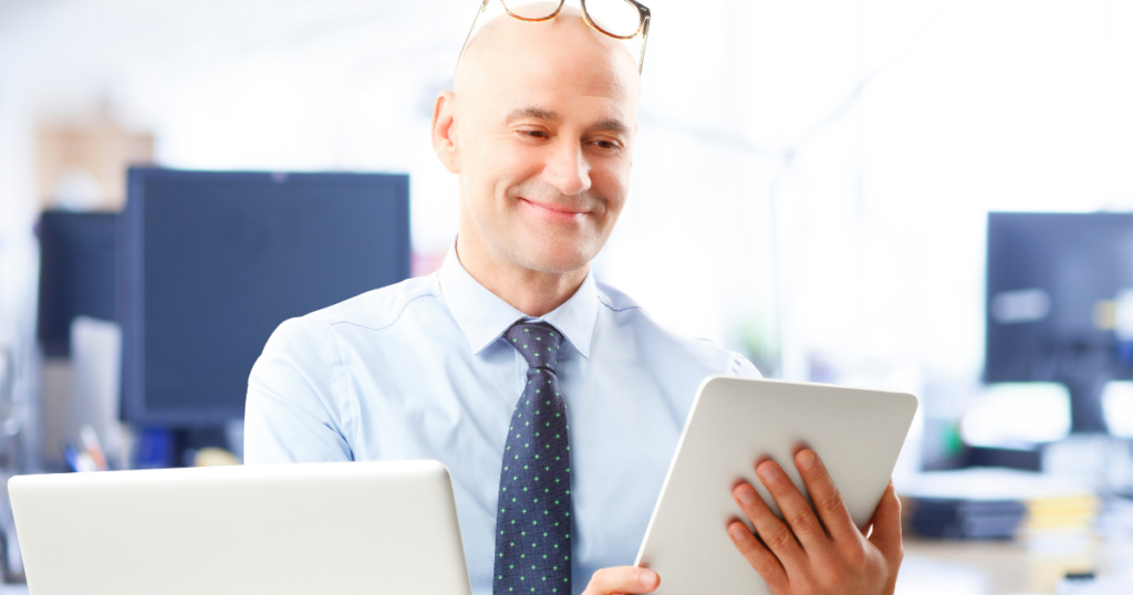 How Quality Monitoring Transforms your Enterprise - happy businessman looking at tablet