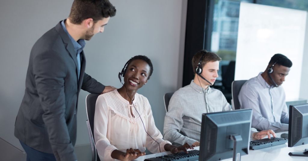 What is Call Center Human Verified AI Quality Assurance? - smiling call center agent getting feedback from coach or trainer