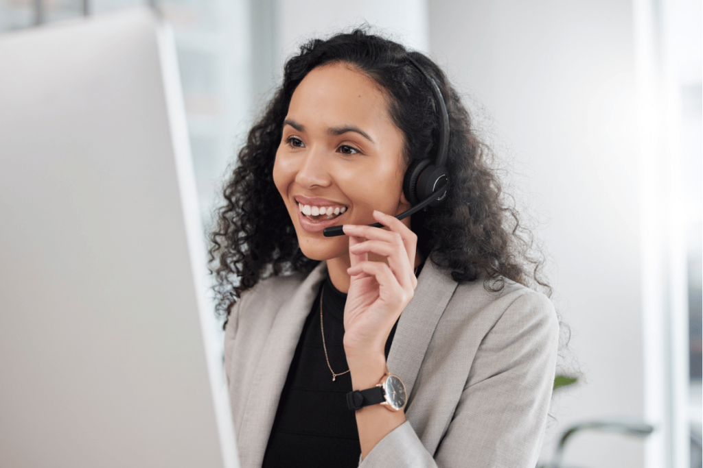 Dramatically Improve Your Contact Center in Just 90 Days. A smiling female contact center agent looks at her computer screen.