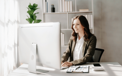 Thanks to AI, Now You Can Automate Quality Assurance. A smiling businesswoman works at her computer in her office.