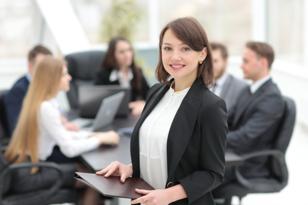 How to Improve Customer Service in Your Bank's Contact Center. A successful business woman stands in front of her team.