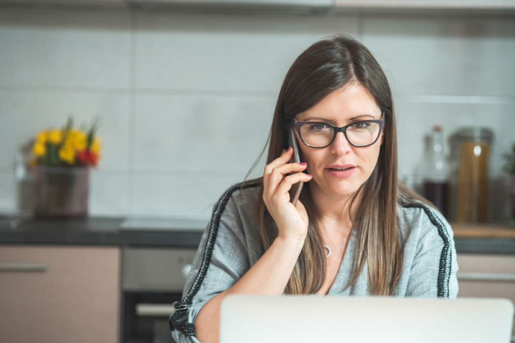 What Are You Missing from Your Call Monitoring? A woman with glasses has a concerned expression on her face as she talks on her phone to customer service reps.