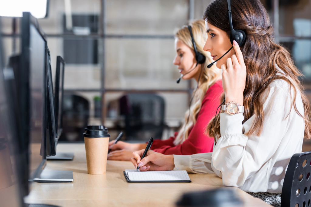 Is My Call Center Ready for Quality Assurance? two female call center employees work at their computers wearing headsets.